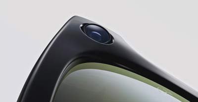 Close-up view of a smart glasses camera embedded in the top corner of the frame, highlighting the compact lens design.