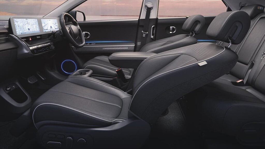 Hyundai Ioniq 5 interior showcasing spacious lounge-style cabin with reclining front seats, dual 12.3-inch digital screens, ambient lighting, and eco-friendly leather upholstery.