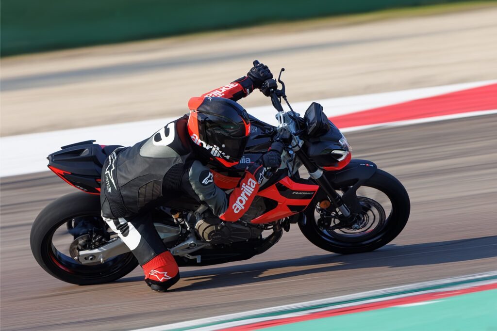 Aprilia Tuono 457 leaning aggressively on racetrack, showcasing performance handling and sporty riding dynamics