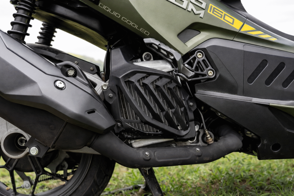 Hero Xoom 160 liquid-cooled engine close-up showing radiator guard, exhaust system and rugged underbody components