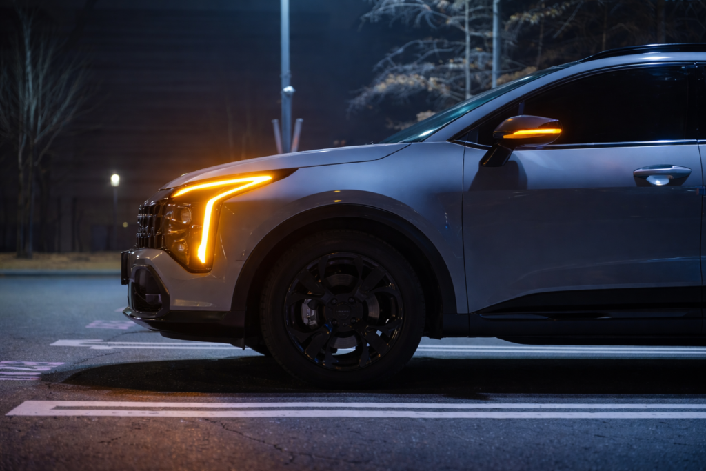Kia Sportage Hybrid front-side night view highlighting LED DRLs and premium SUV design